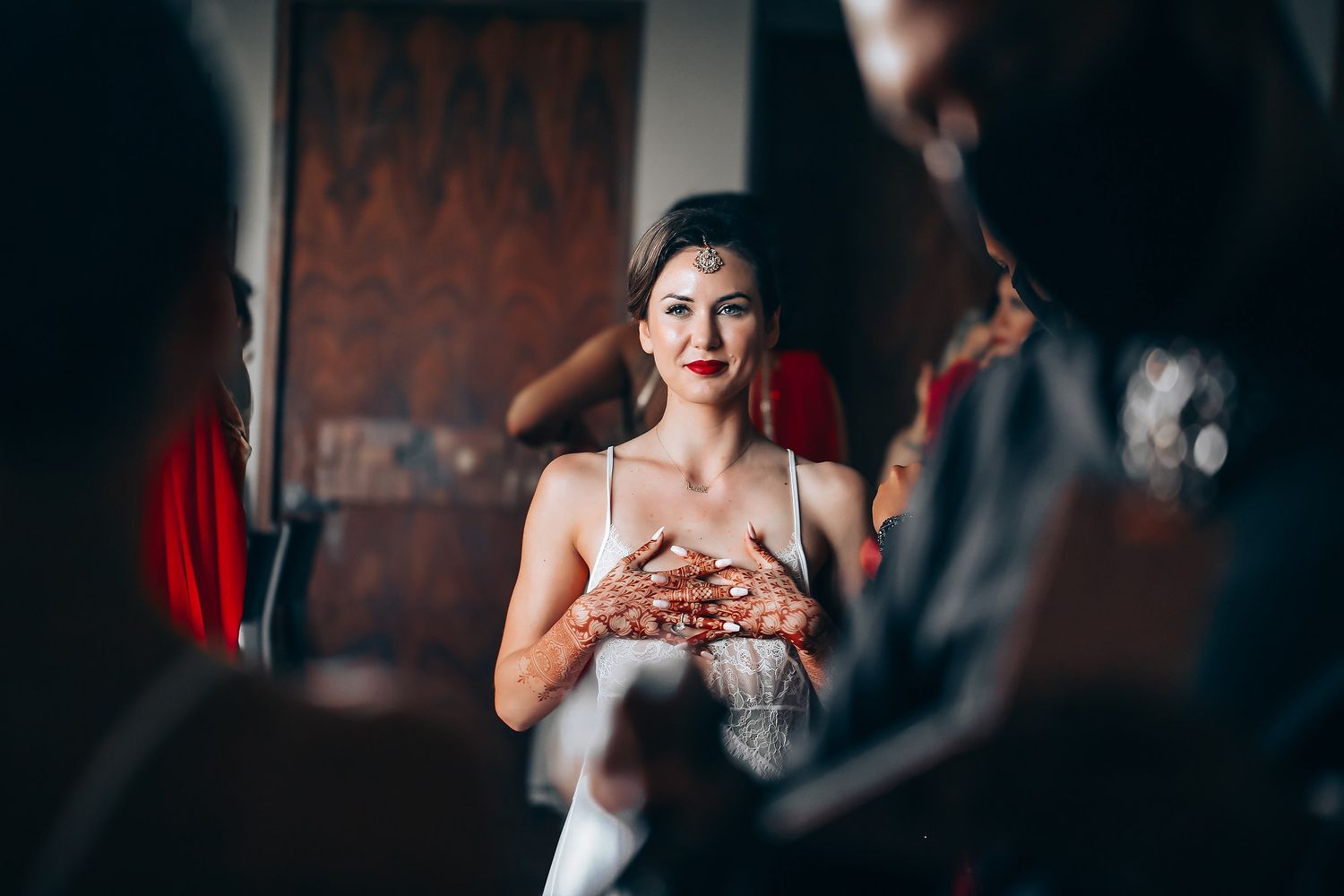 A couple shares an intimate dance moment together at an elegant indoor venue with moody lighting.