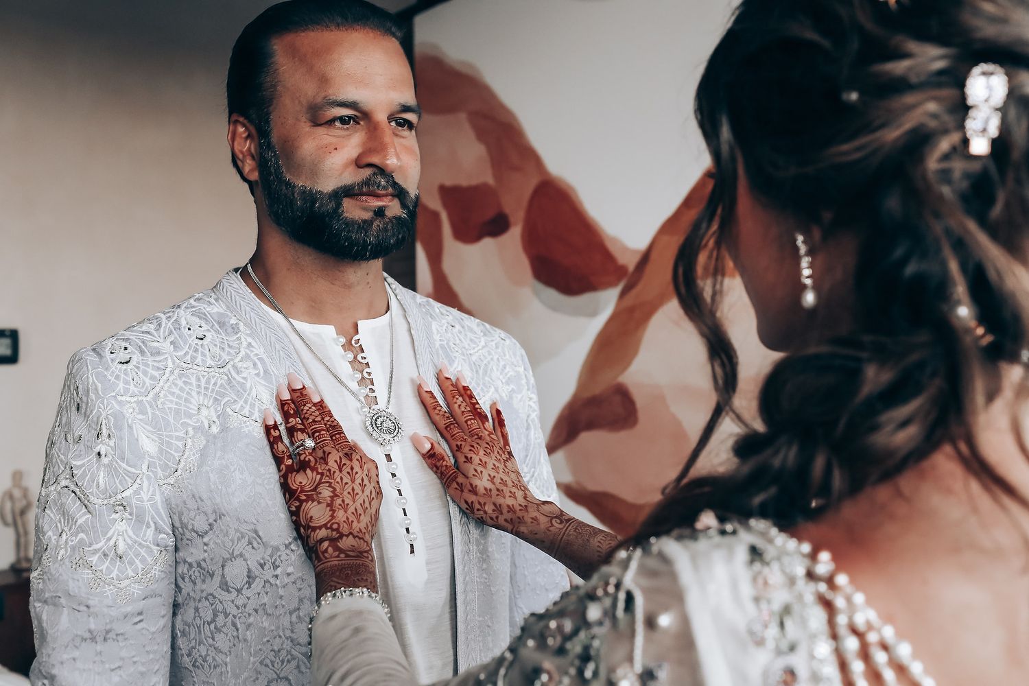 A collage of wedding photos showing traditional Indian mehndi designs and white wedding attire details.
