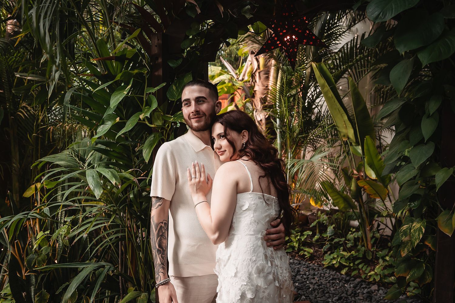 Intimate moment captured in a lush tropical garden setting with natural greenery.