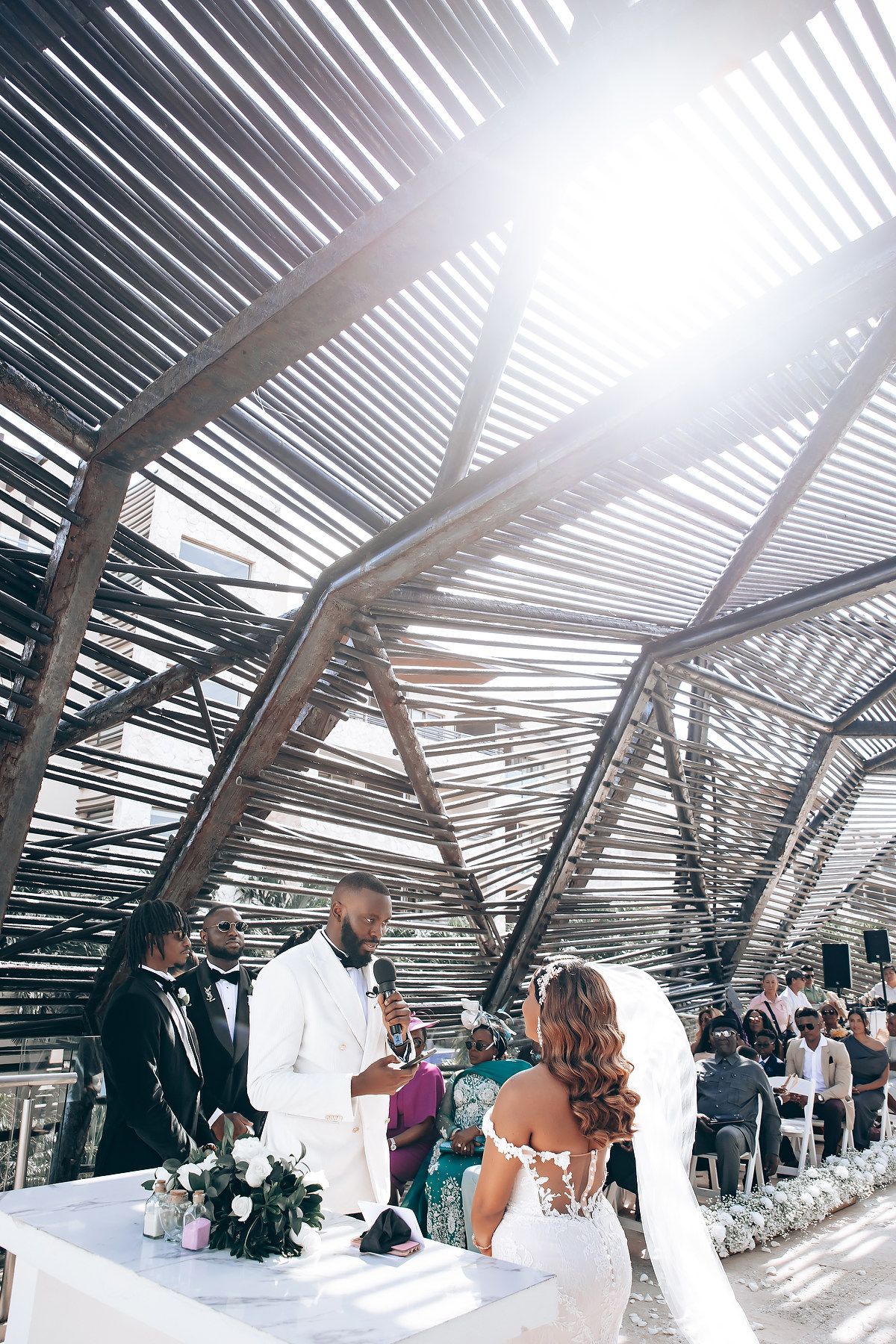 Panoramic sequence of a modern wedding ceremony under a slatted roof structure with natural light streaming through.