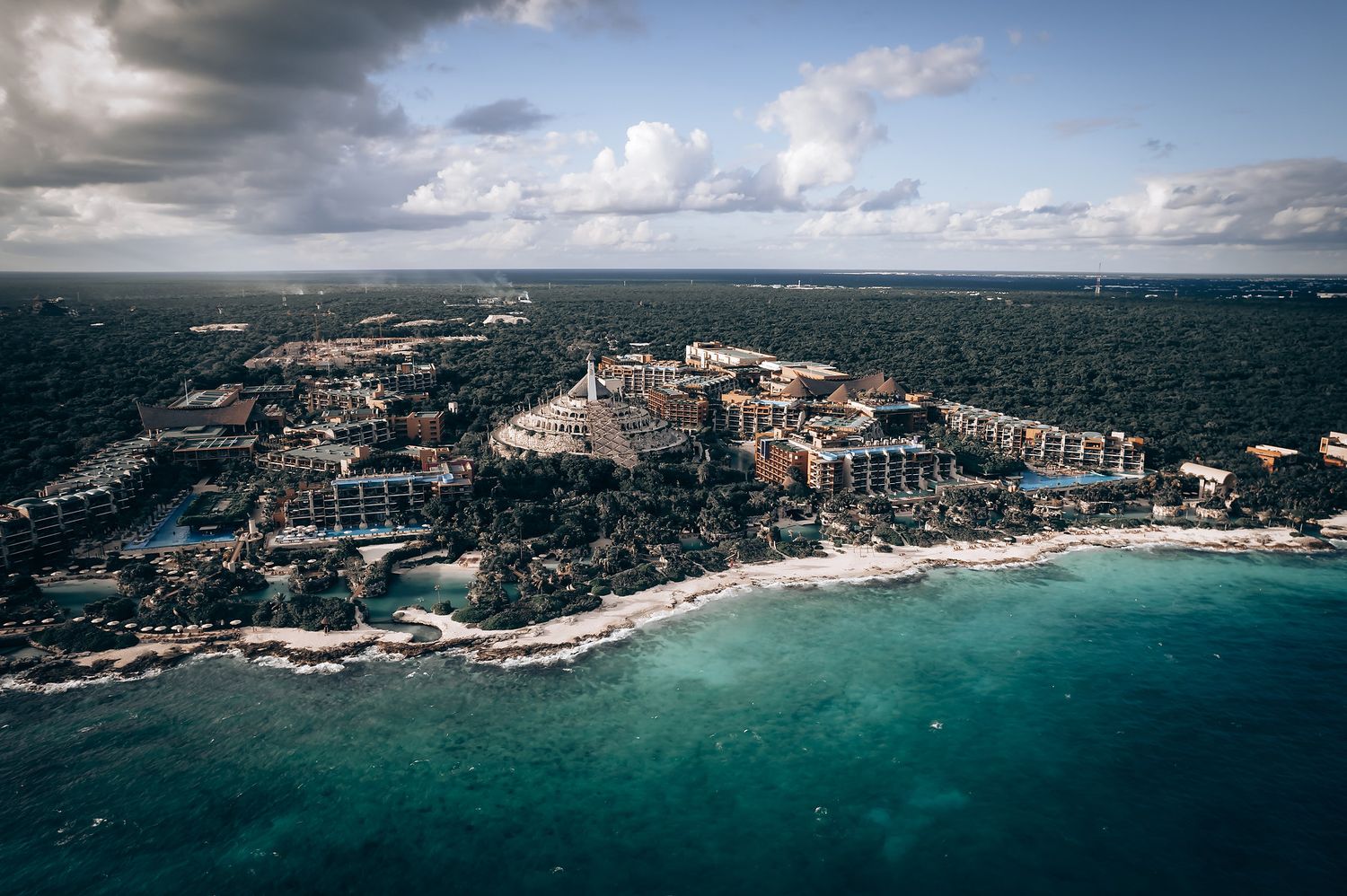 Aerial panorama of a coastal resort area with turquoise waters and luxury developments.