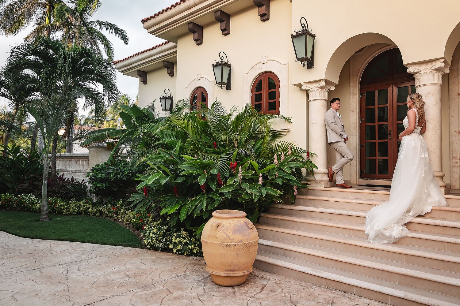 Elegant Spanish colonial venue with terra cotta pots and palm trees creates perfect wedding backdrop.
