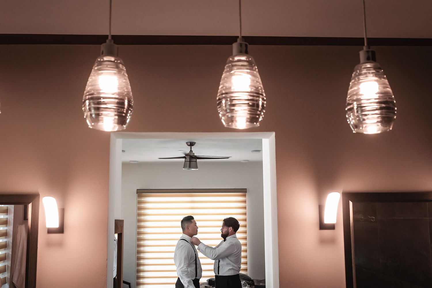 Modern interior space with hanging pendant lights and window blinds.