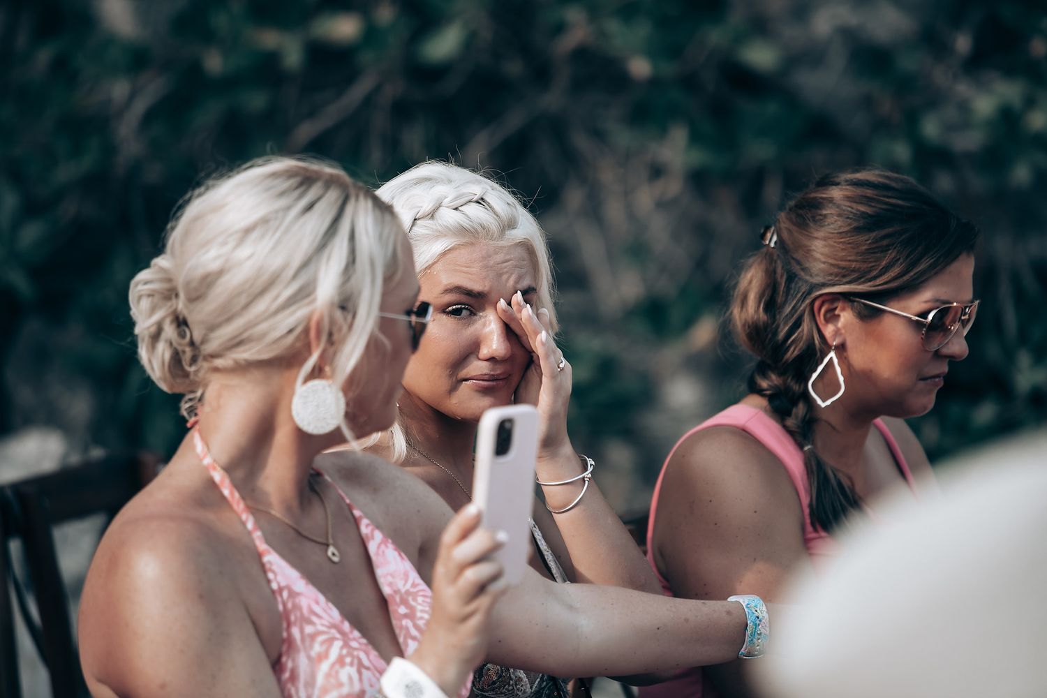 Wedding guests taking photos during outdoor celebration.