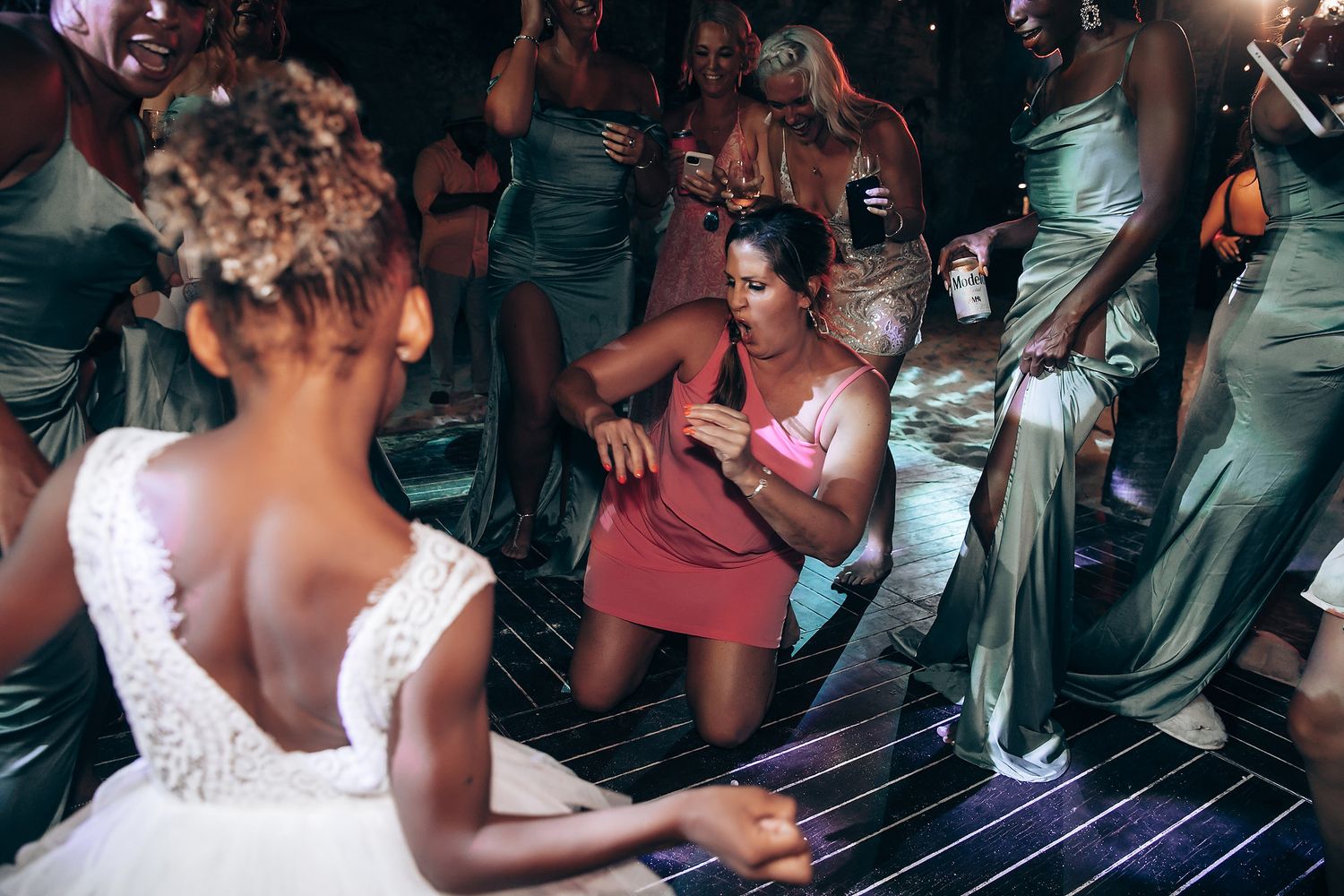 Lively dance floor scene at a wedding reception with guests in formal attire.