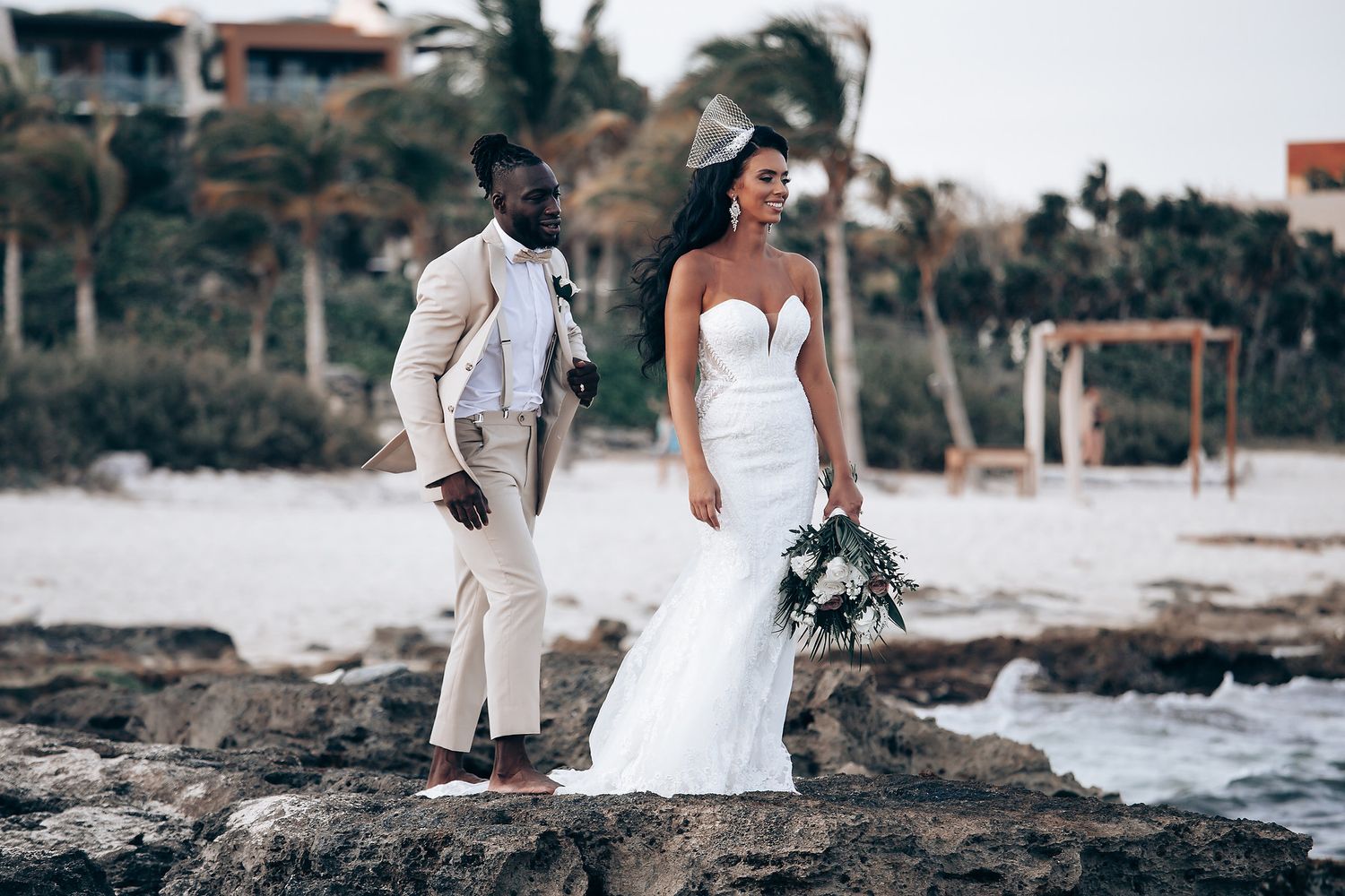 Beachside wedding ceremony with couple posing against scenic coastal backdrop.