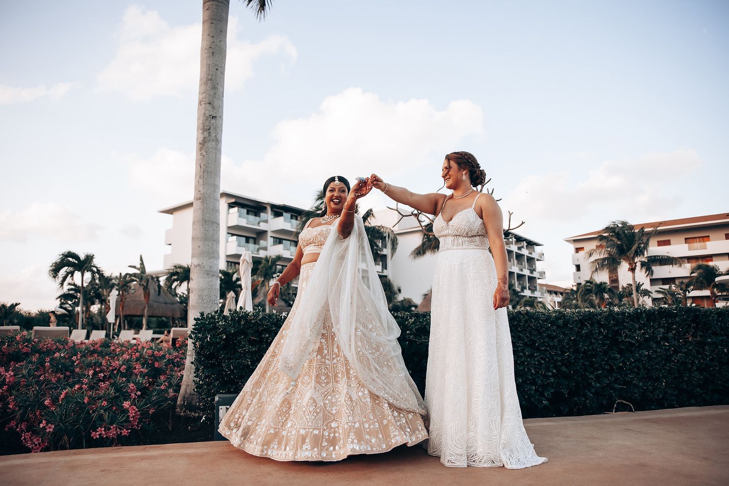 Wedding party members in elegant traditional Indian outfits pose on an outdoor terrace.
