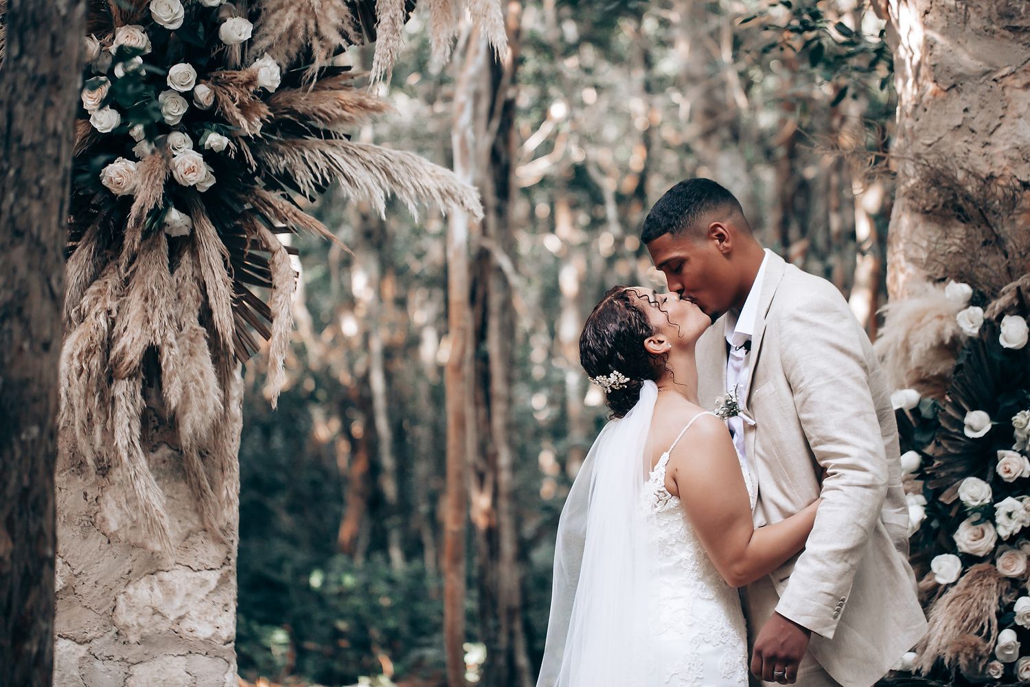 Wedding ceremony participants gathered in a rustic forest setting.