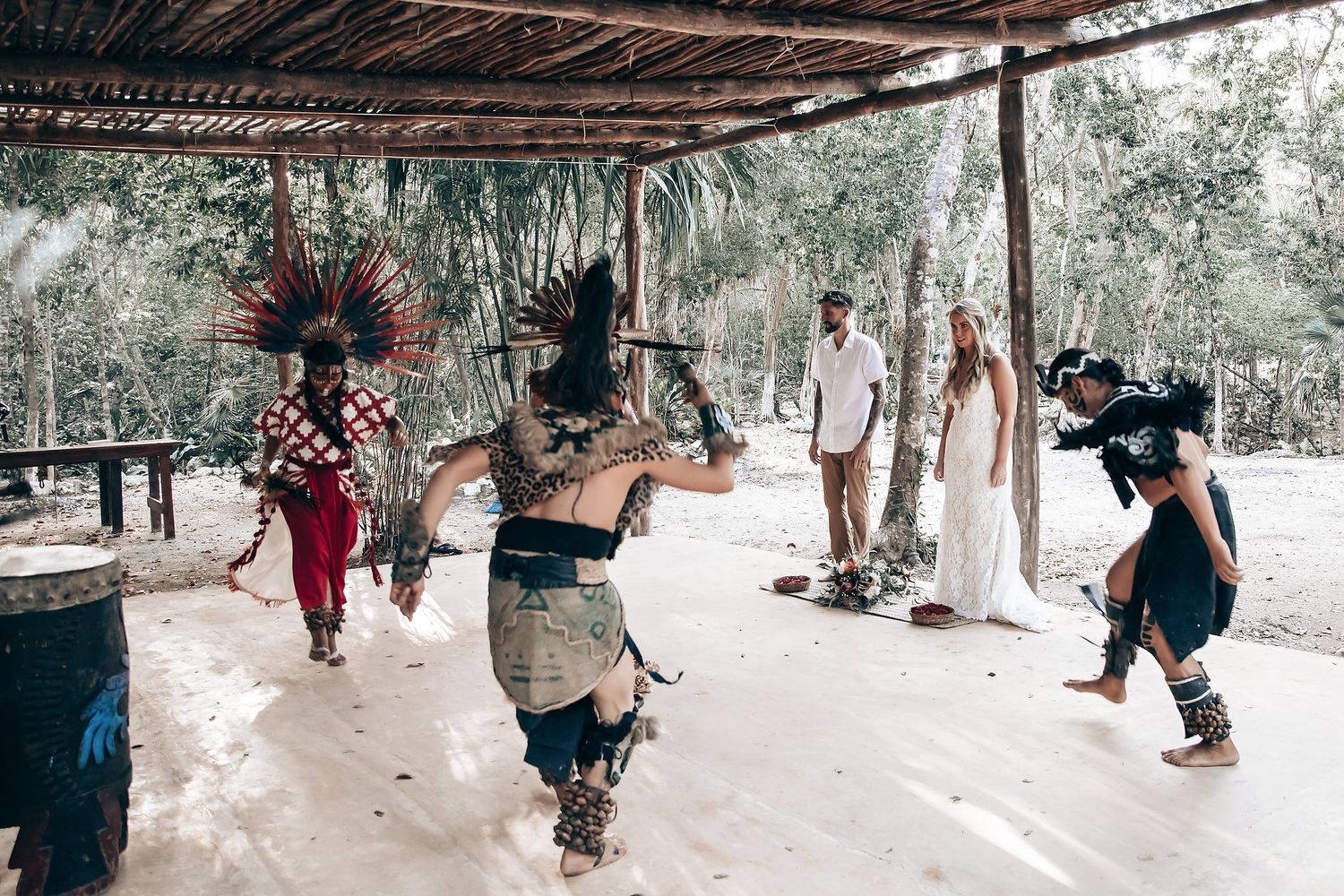 Group walking through a wooded path during what appears to be a ceremonial procession.