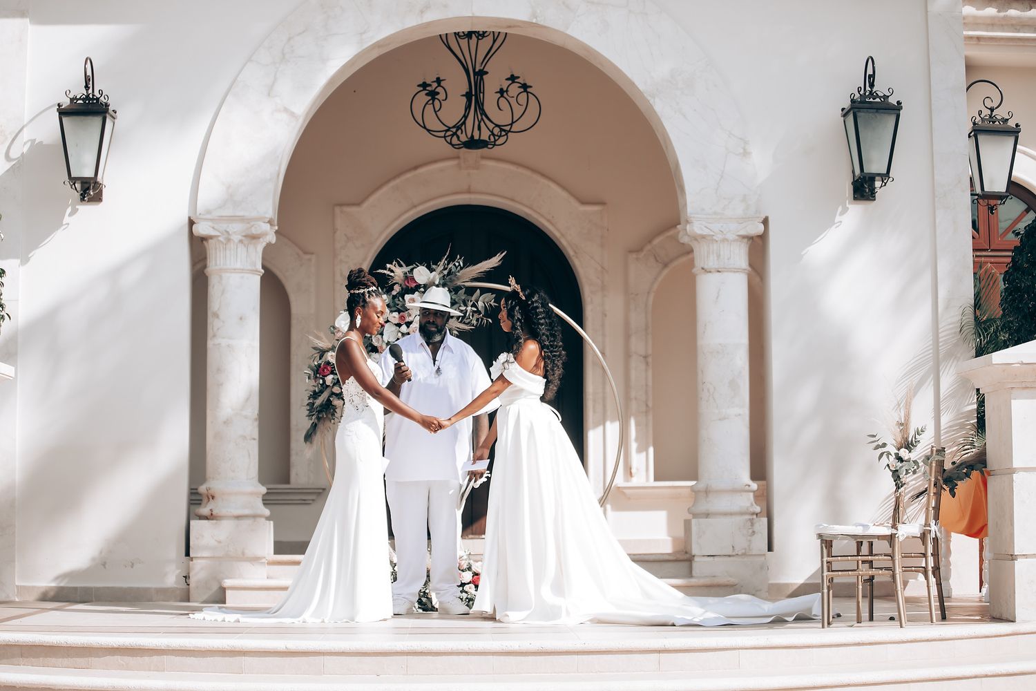 An elegant wedding venue with arched walkways, lanterns and white columns.