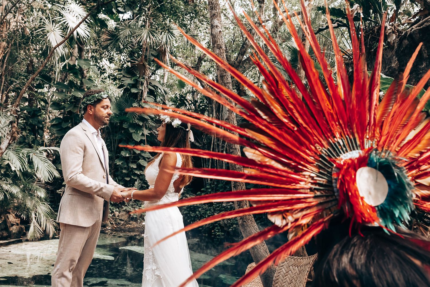 Traditional Mayan ceremony featuring vibrant red feathered headdress in a lush jungle setting.
