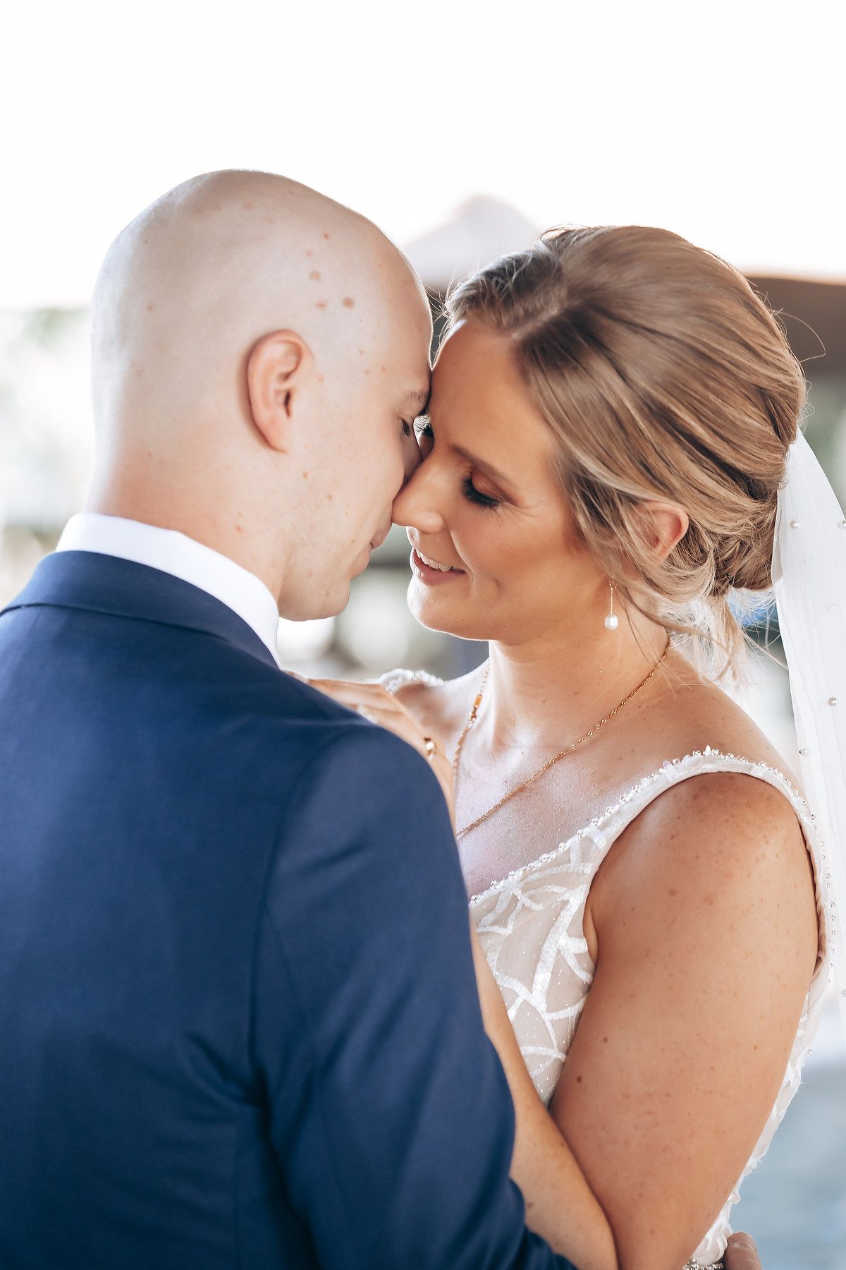 A close-up portrait of a bride and groom embracing on their wedding day.