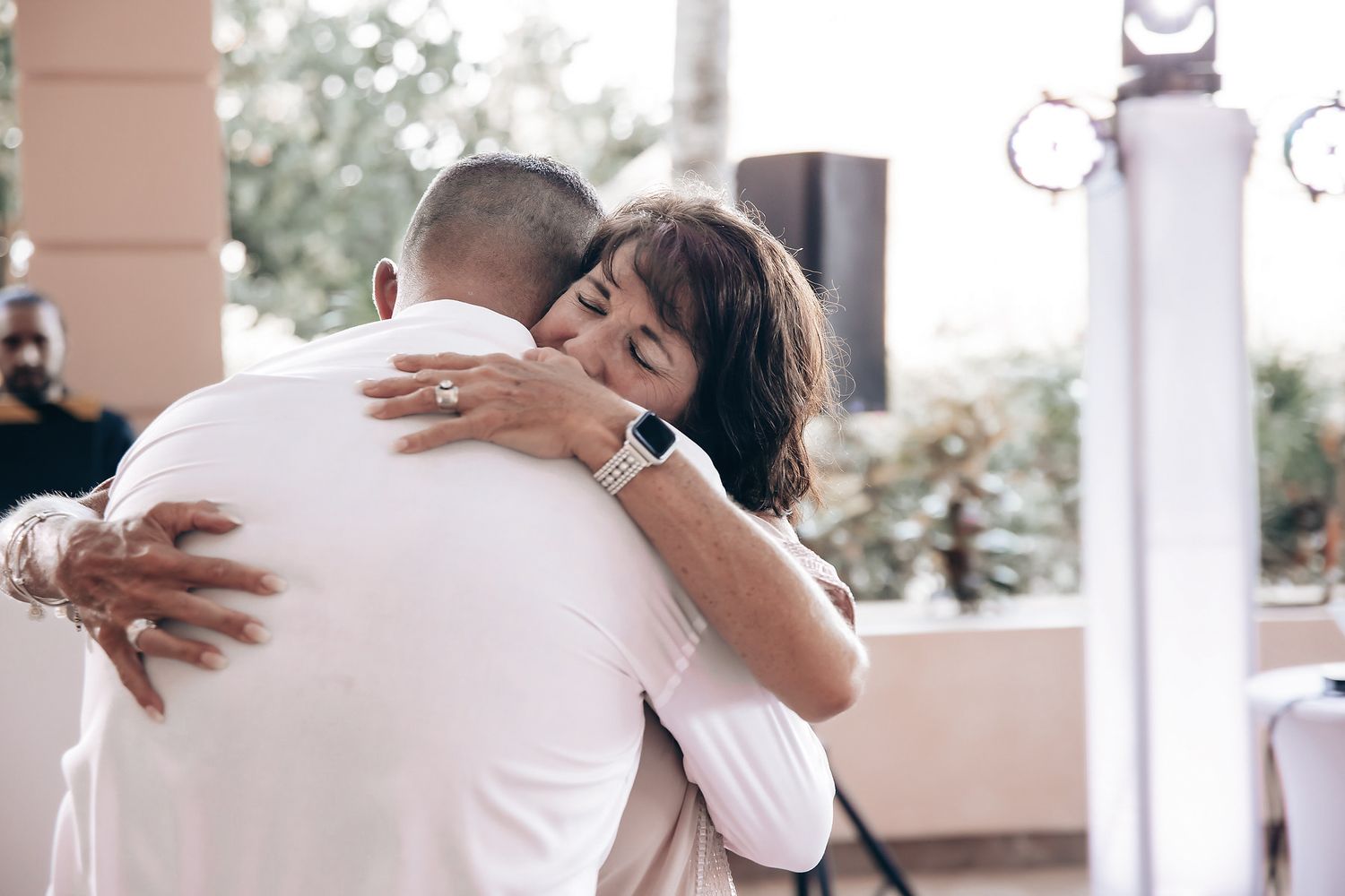 A couple embraces and kisses tenderly in a romantic outdoor setting.