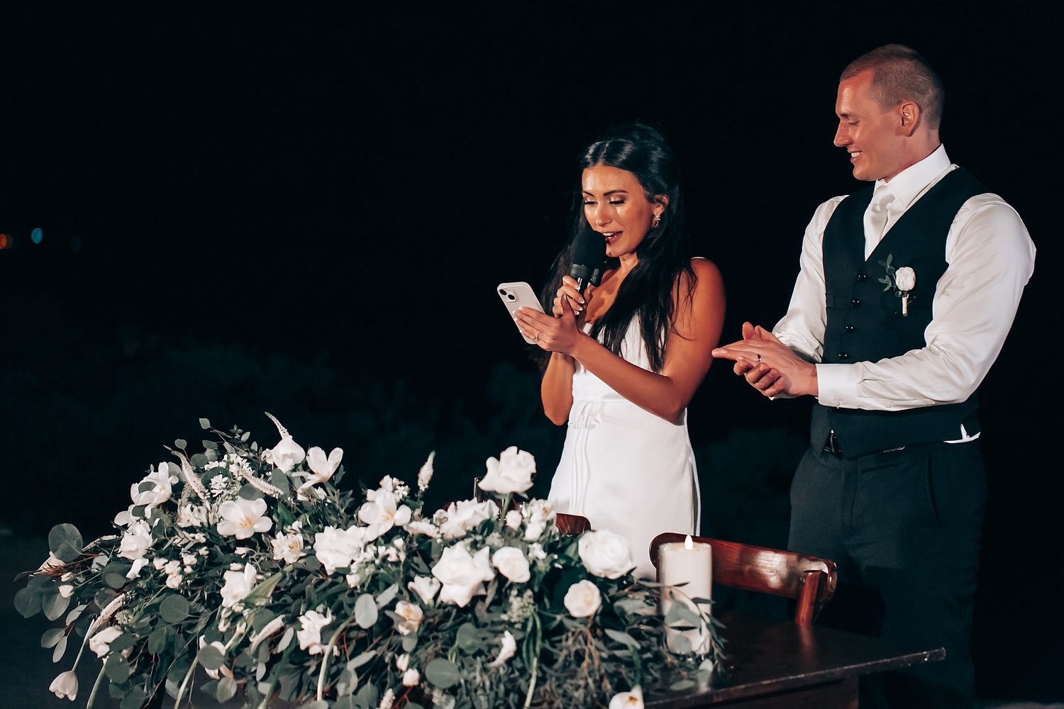 Wedding reception with elegant white floral centerpieces and ambient lighting.
