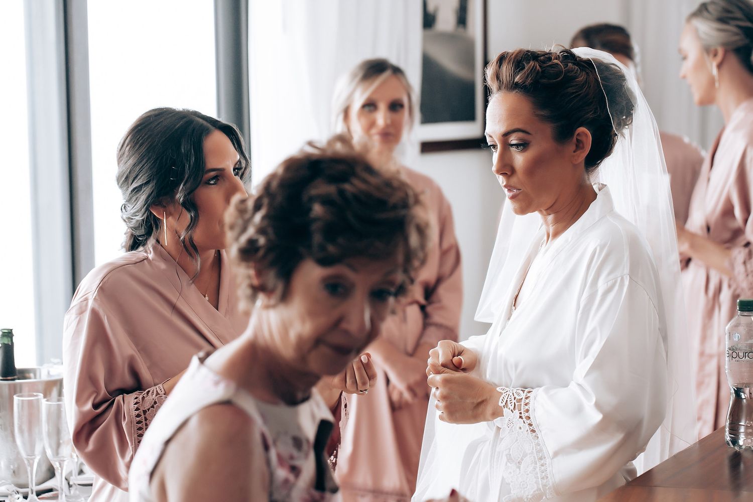 A group of people wearing white robes gather together in a bright, airy room during a spa or wellness event.