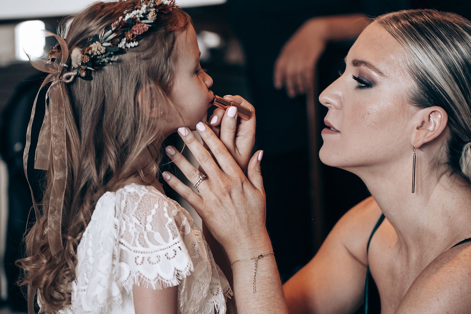 A romantic wedding photoshoot shows a couple sharing intimate kisses in a dark, moody setting.