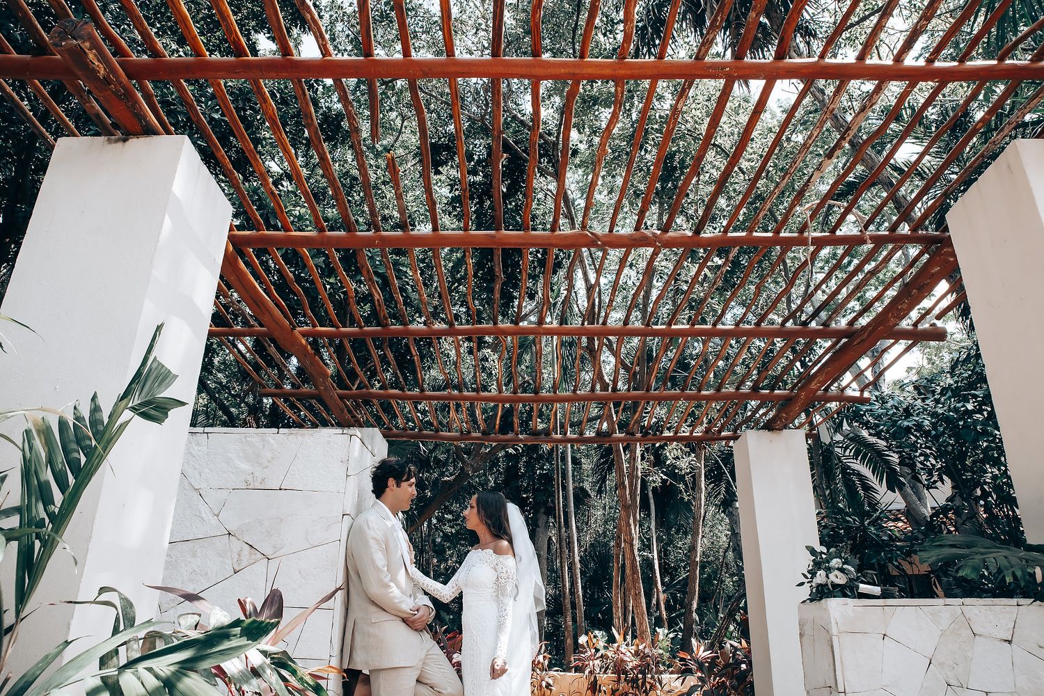Wedding venue interior decorated with rustic wooden beams and hanging lights creates a romantic atmosphere.