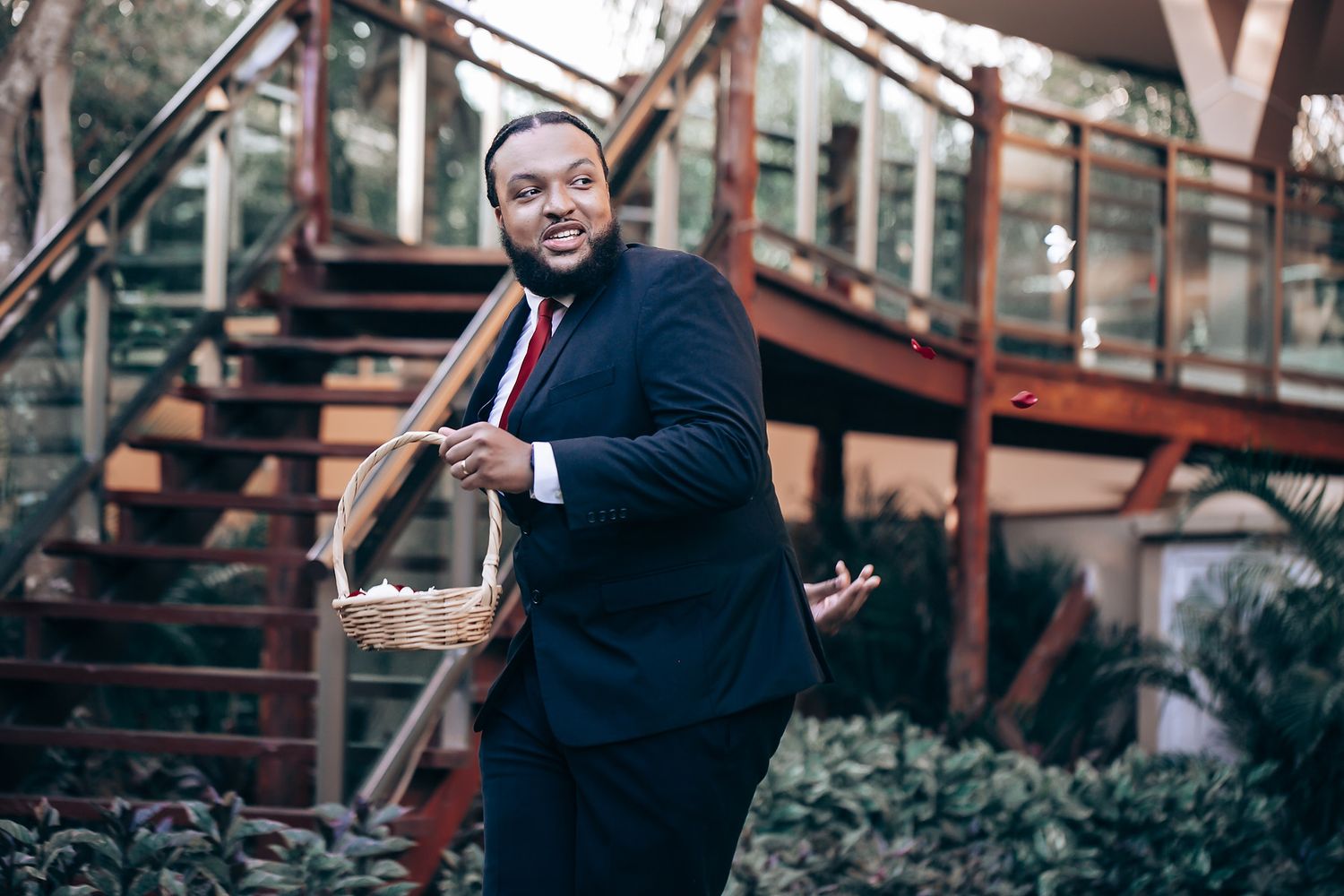 Professional speaker gestures while giving presentation at business conference in front of industrial backdrop.