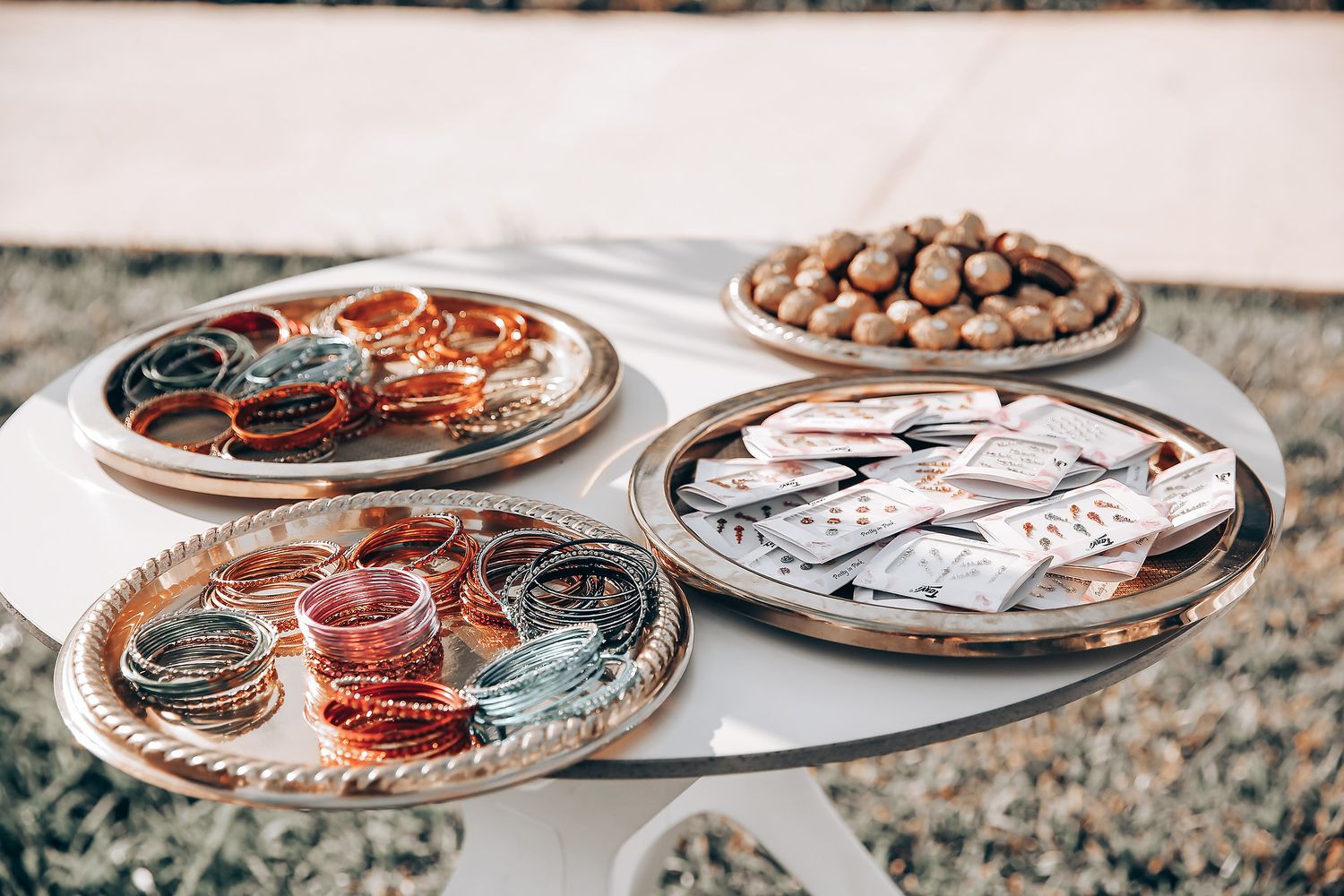 Ornate silver and copper decorative plates displayed on a textured gray surface with round elements.