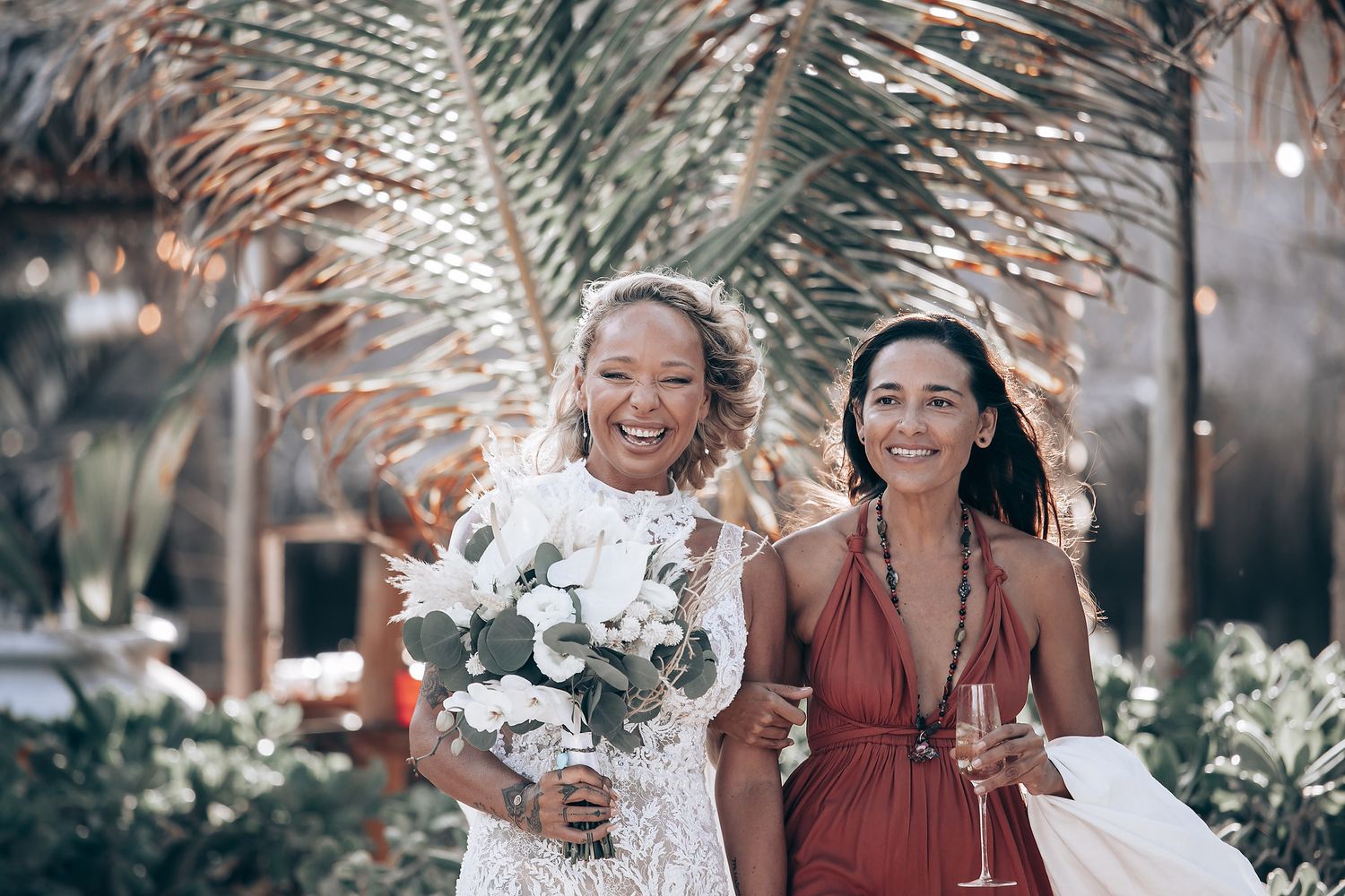 Wedding party celebrating outdoors with burgundy bridesmaid dresses and floral arrangements.