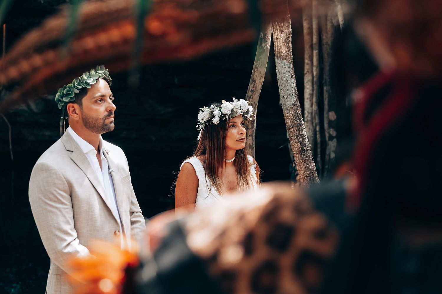 Outdoor ceremony in a tropical forest with traditional decorative elements.