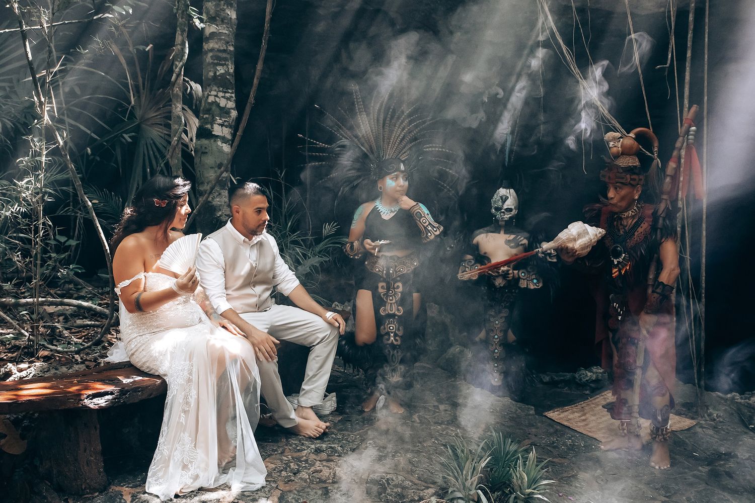 A traditional Mayan ritual ceremony takes place in a smoke-filled setting with white attire.