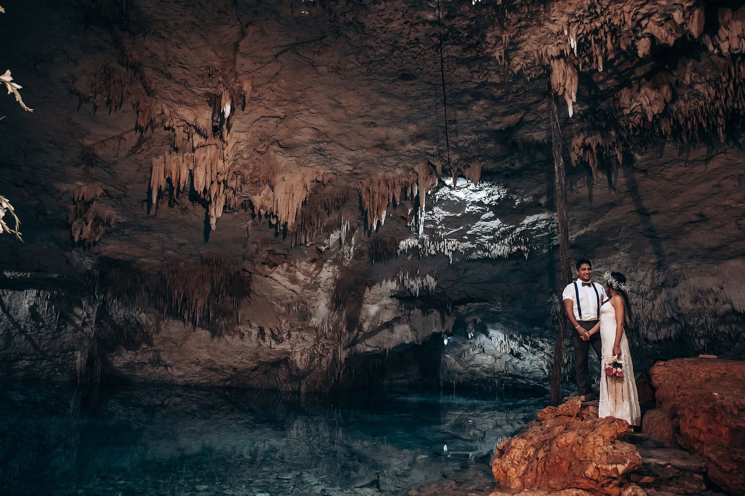 Underground cave wedding venue with rustic stone floors and atmospheric lighting from placed luminaries.
