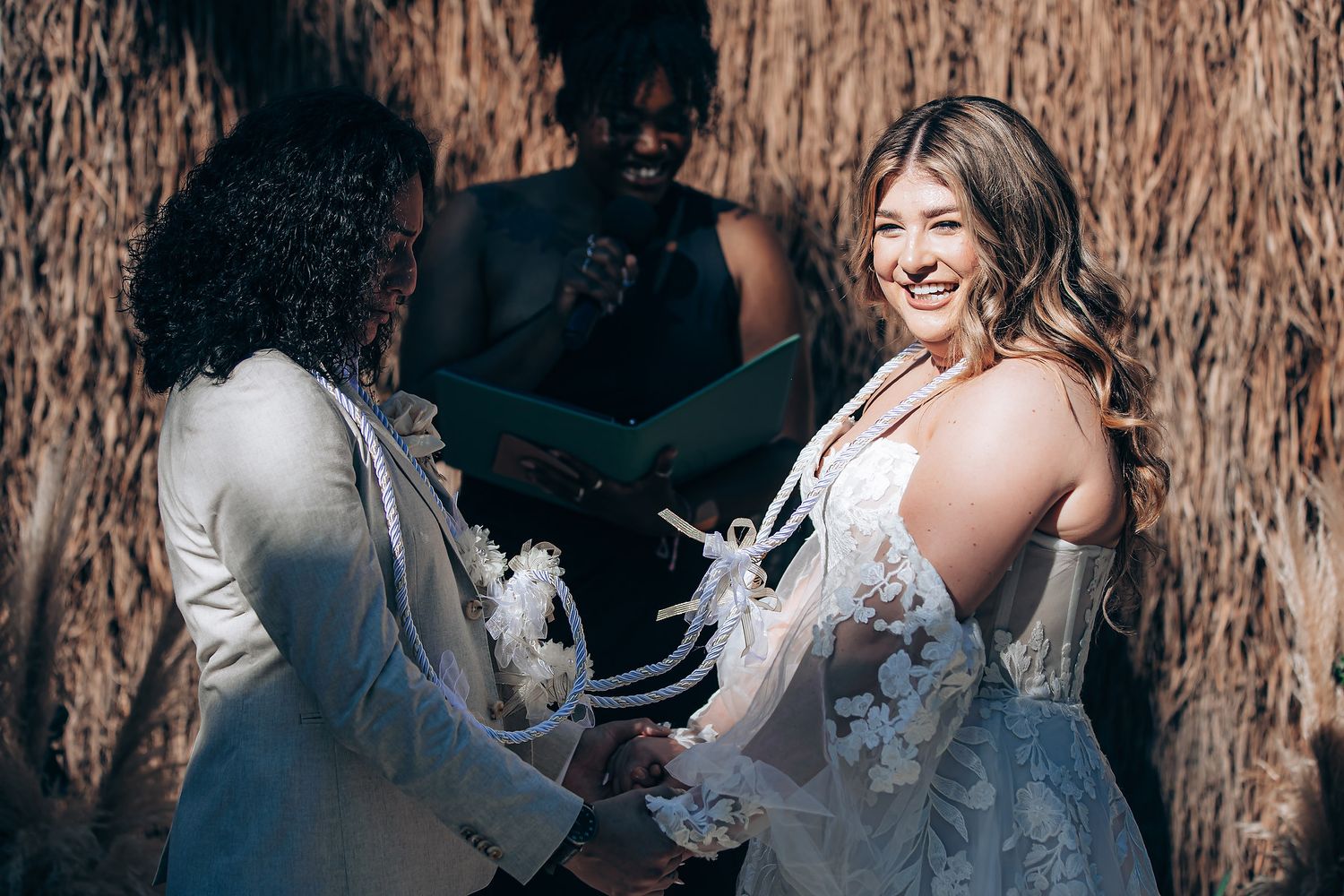A couple shares a joyful moment together while standing in front of a rustic wooden wall.
