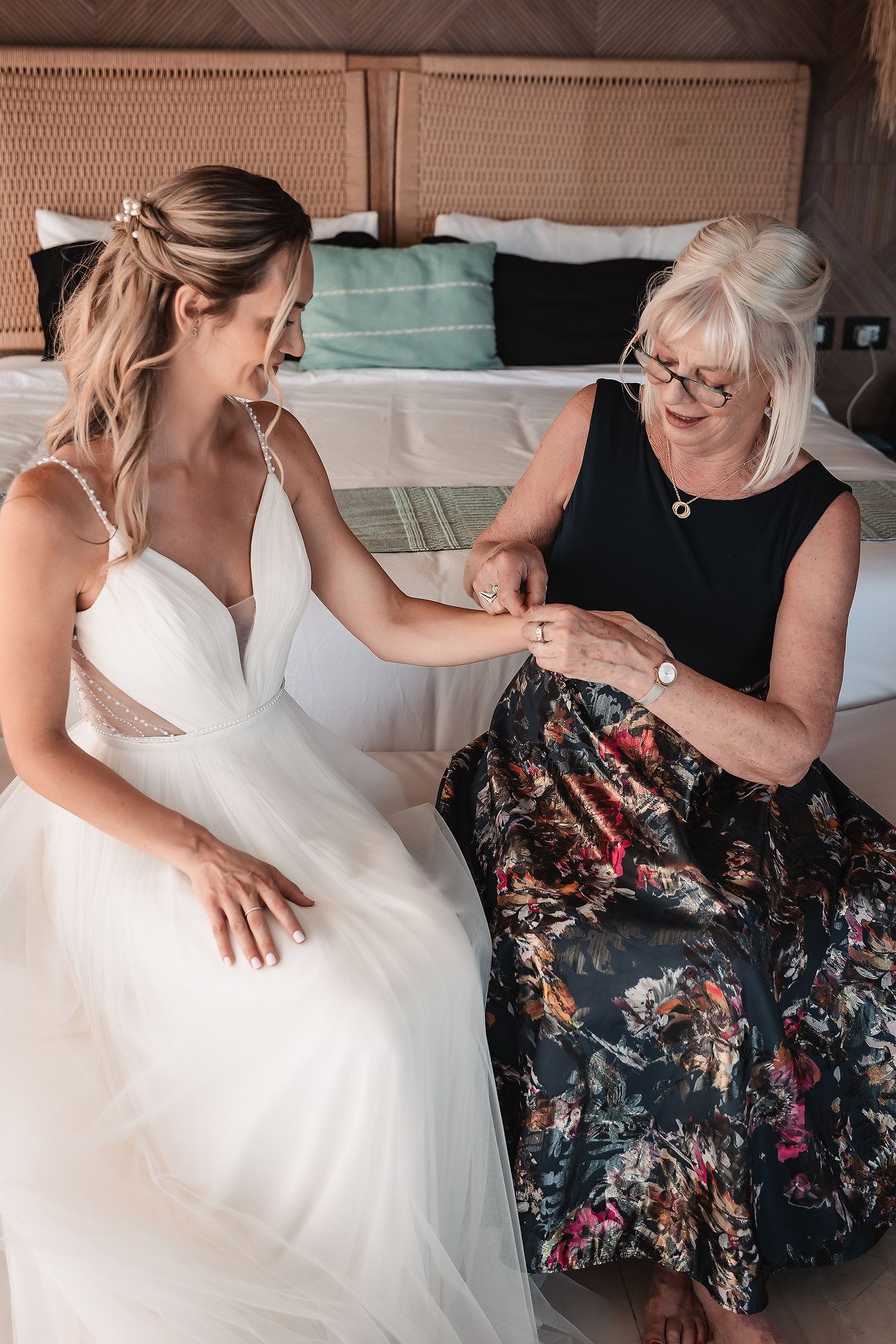 Wedding dress preparation with attendants helping with the gown's details.
