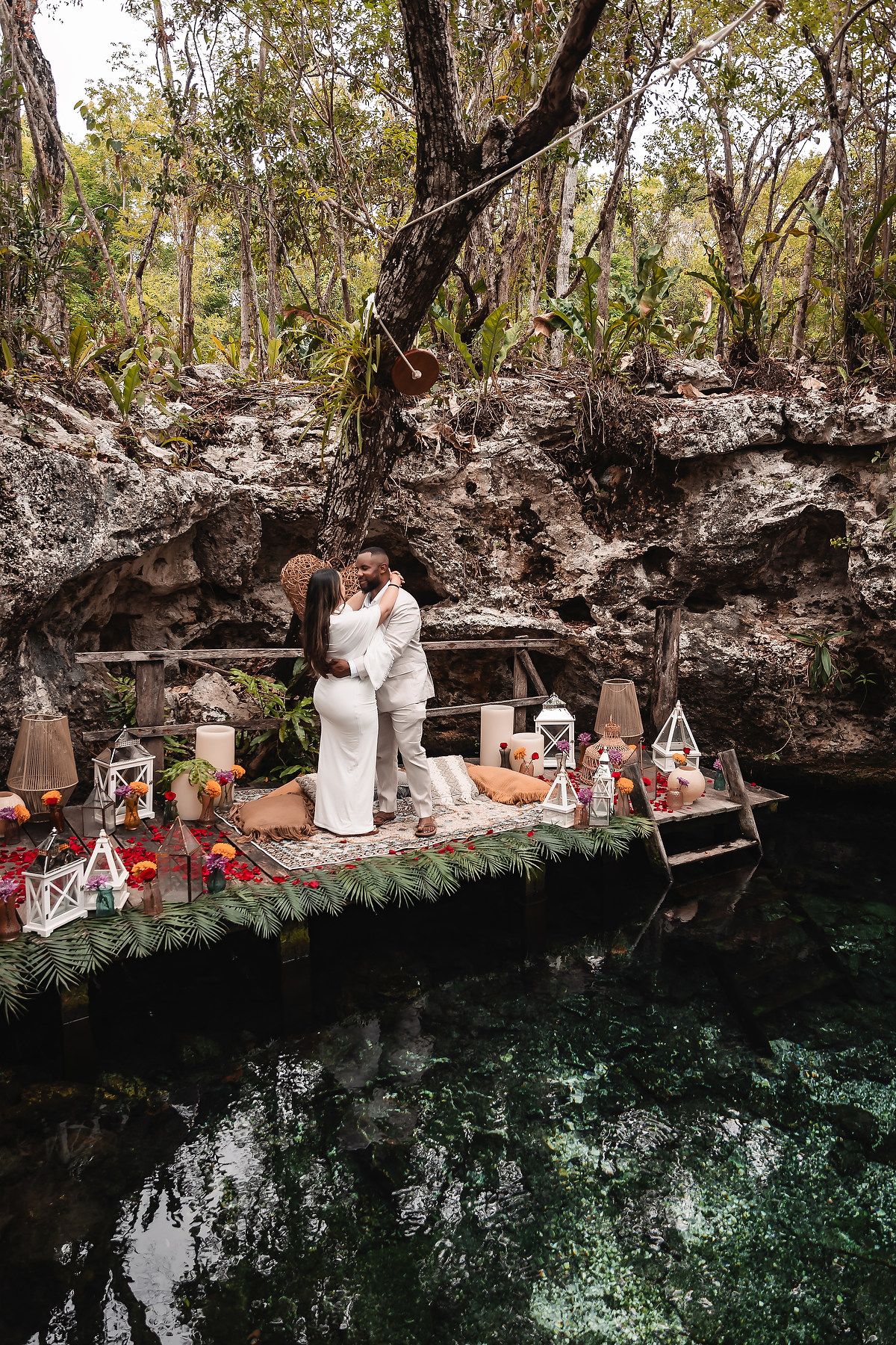 Intimate celebration setup along a natural cenote cave with clear turquoise water below.