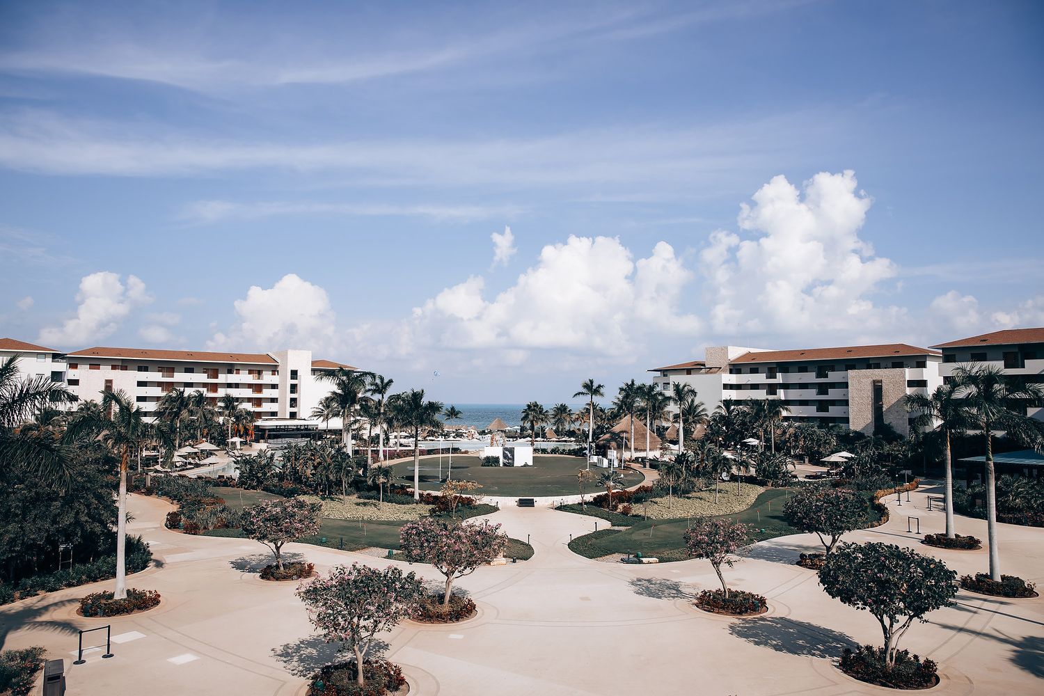 A panoramic view of a beachfront community with coastal buildings and sand dunes under blue skies.
