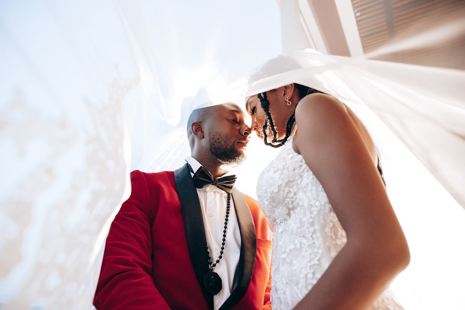 Elegant wedding scene with soft white fabric draping in the background.