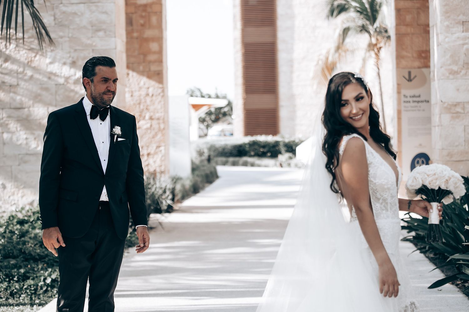 A romantic wedding photo collage showing couples in formal attire embracing at a stone archway venue.