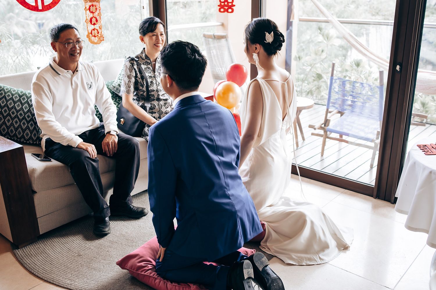 Traditional Chinese tea ceremony taking place indoors by a window with red double happiness symbols.