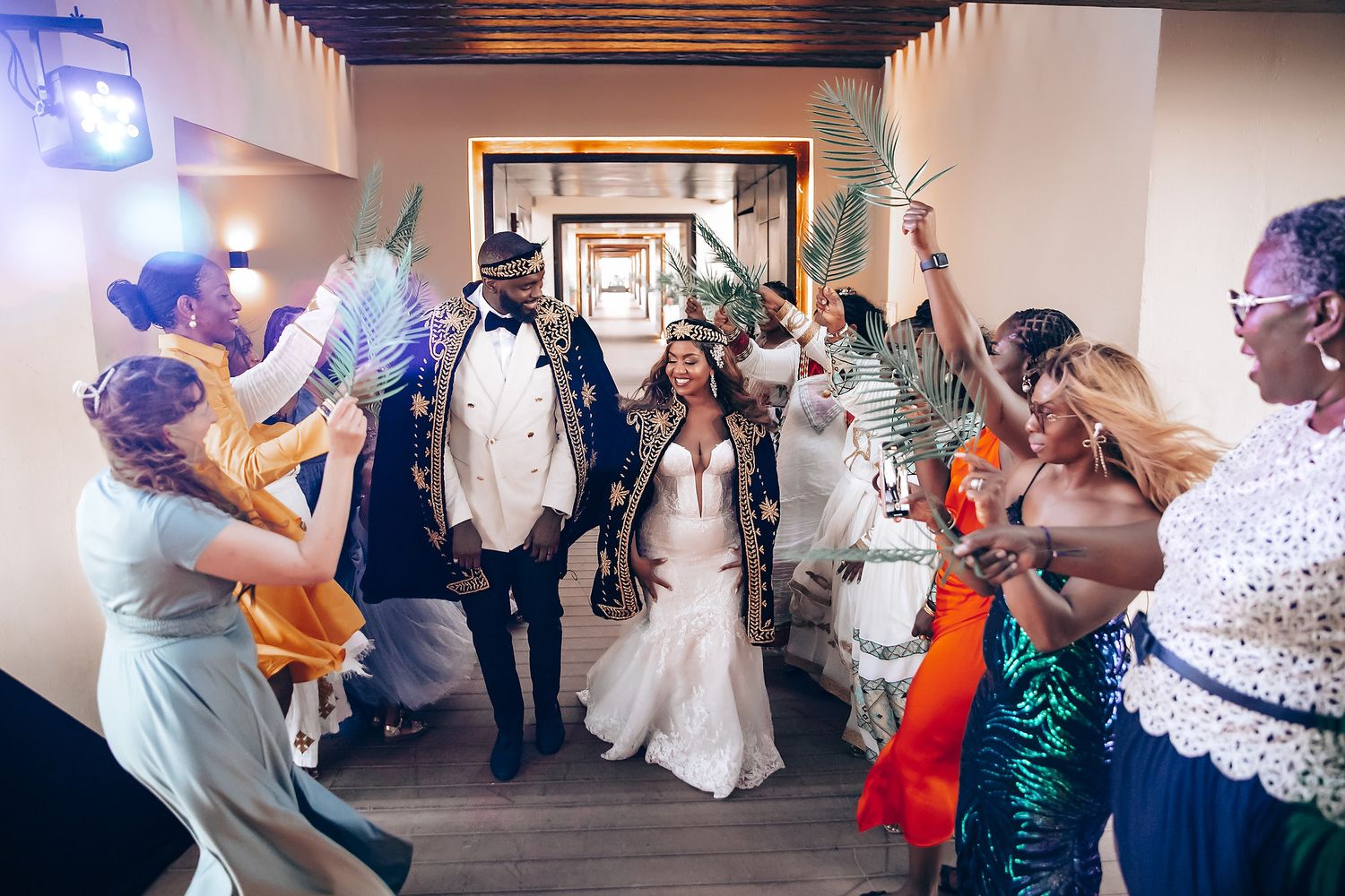 Wedding reception guests dance and celebrate in an indoor venue.