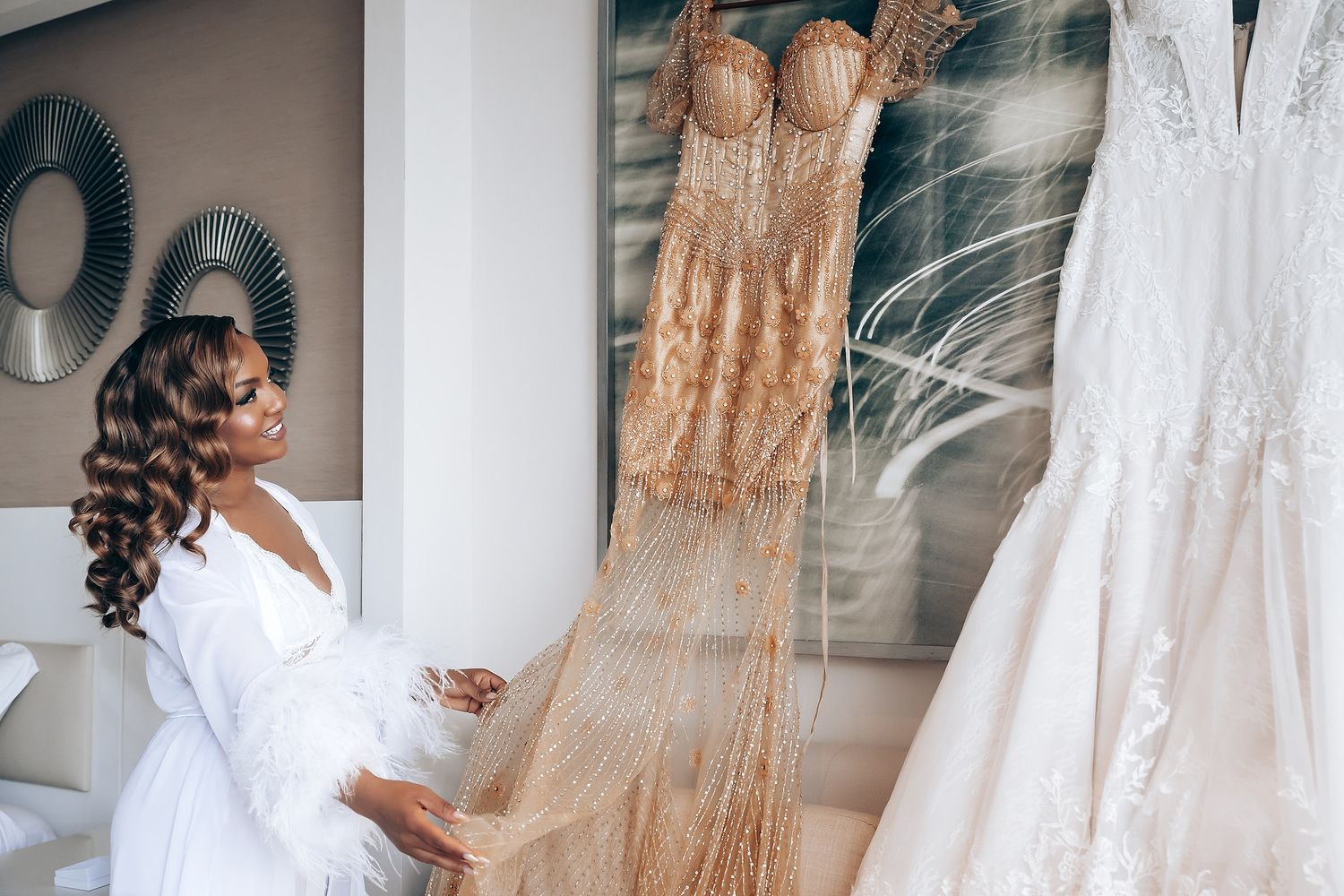 Beautiful bridal gowns displayed on hangers with intricate lace and beading details.