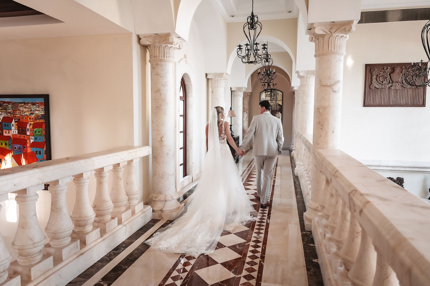 Interior view of a luxurious white hallway with exposed wooden beams and colorful artwork.