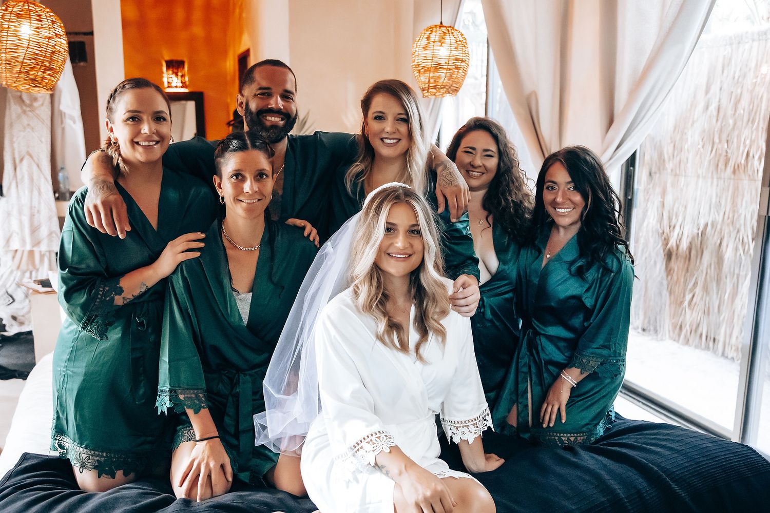 Wedding party members in emerald green robes gather together during pre-ceremony preparations.