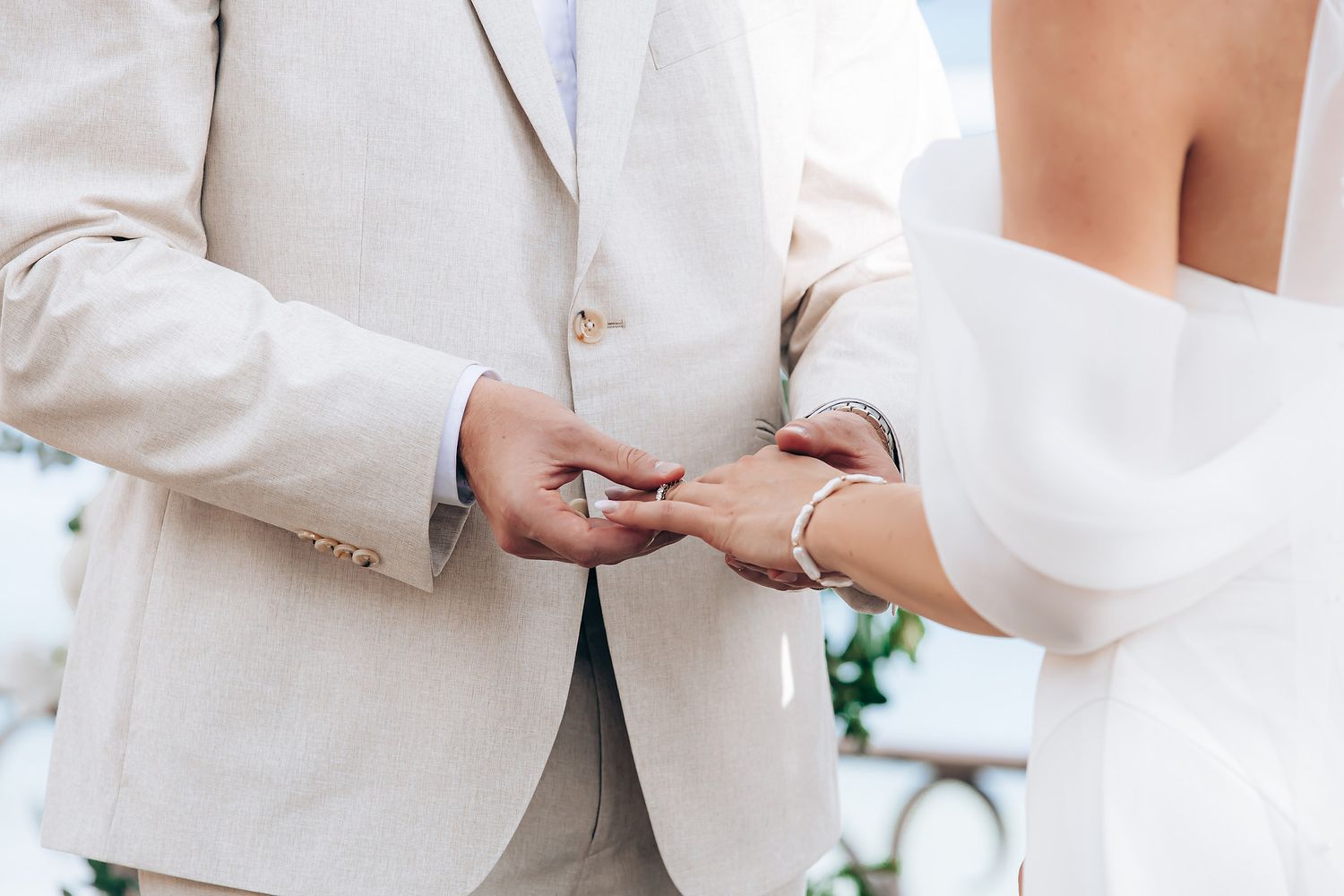 A group of people wearing white formal attire gather together at an outdoor event.