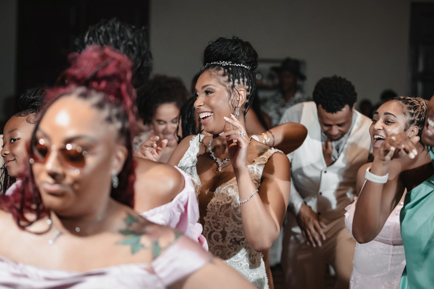 Joyful group of people dancing and celebrating at a lively indoor party event.