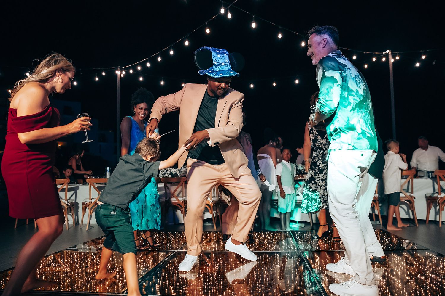 Wedding reception dance floor with colorful lighting and celebrating guests.