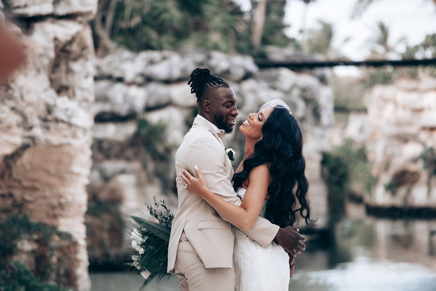 Wedding couple shares intimate moments in series of stone archway photos with natural lighting.