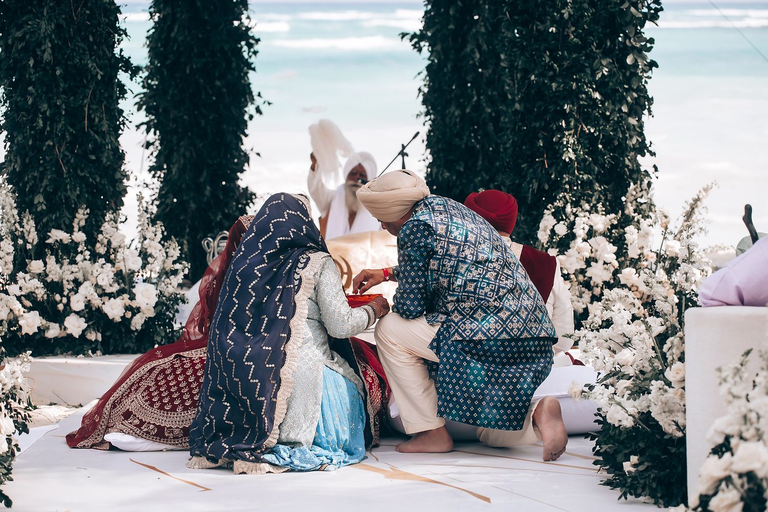 Elegant outdoor wedding ceremony space decorated with hanging greenery and white flowers.