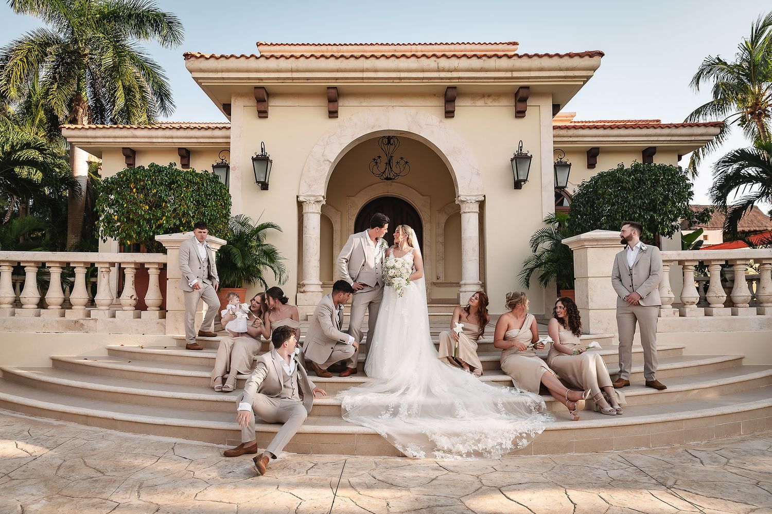 Elegant Mediterranean venue with palm trees and cream colored architecture creates a romantic wedding setting.
