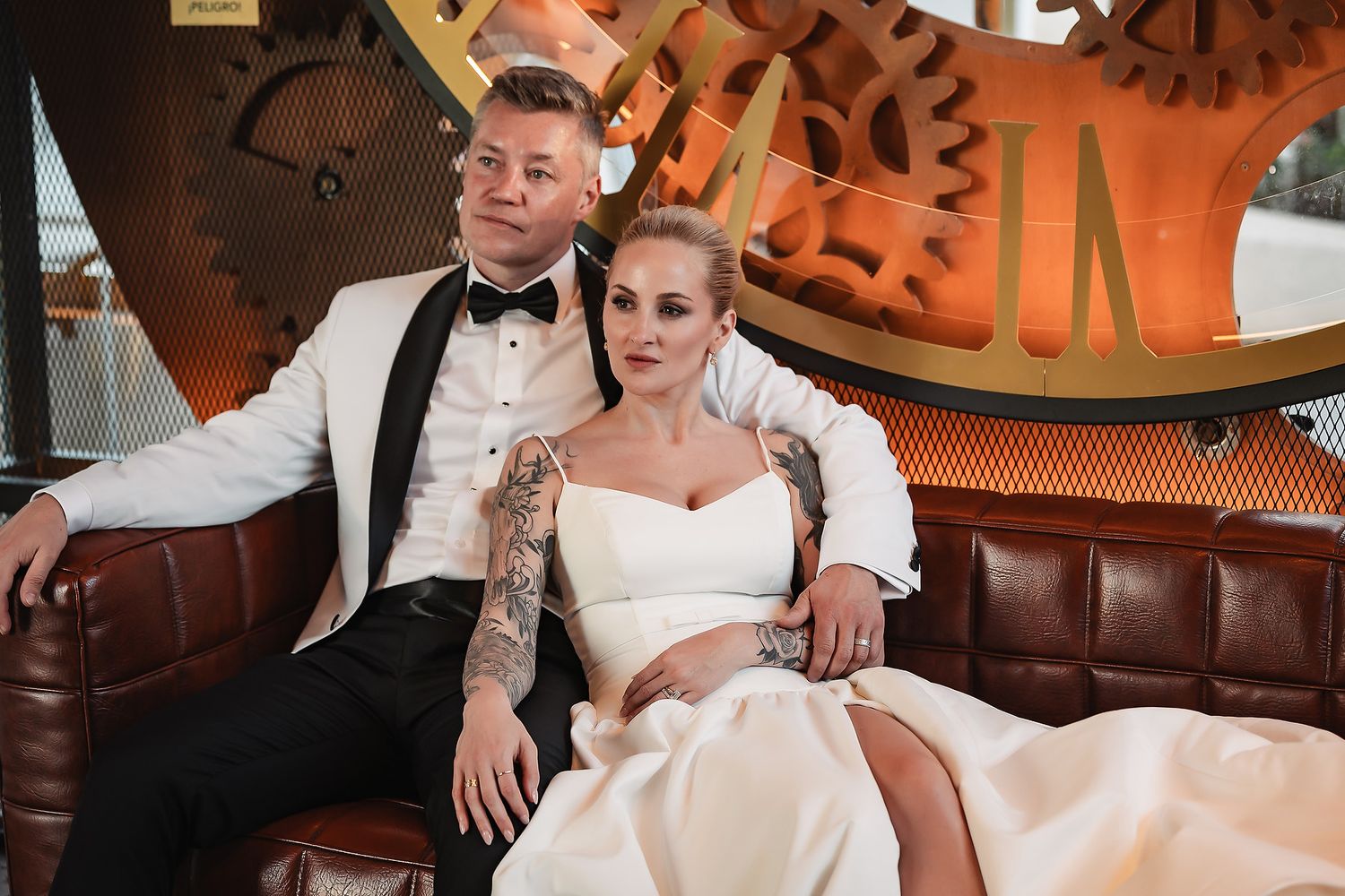 Wedding reception in elegant venue with warm lighting and leather seating.