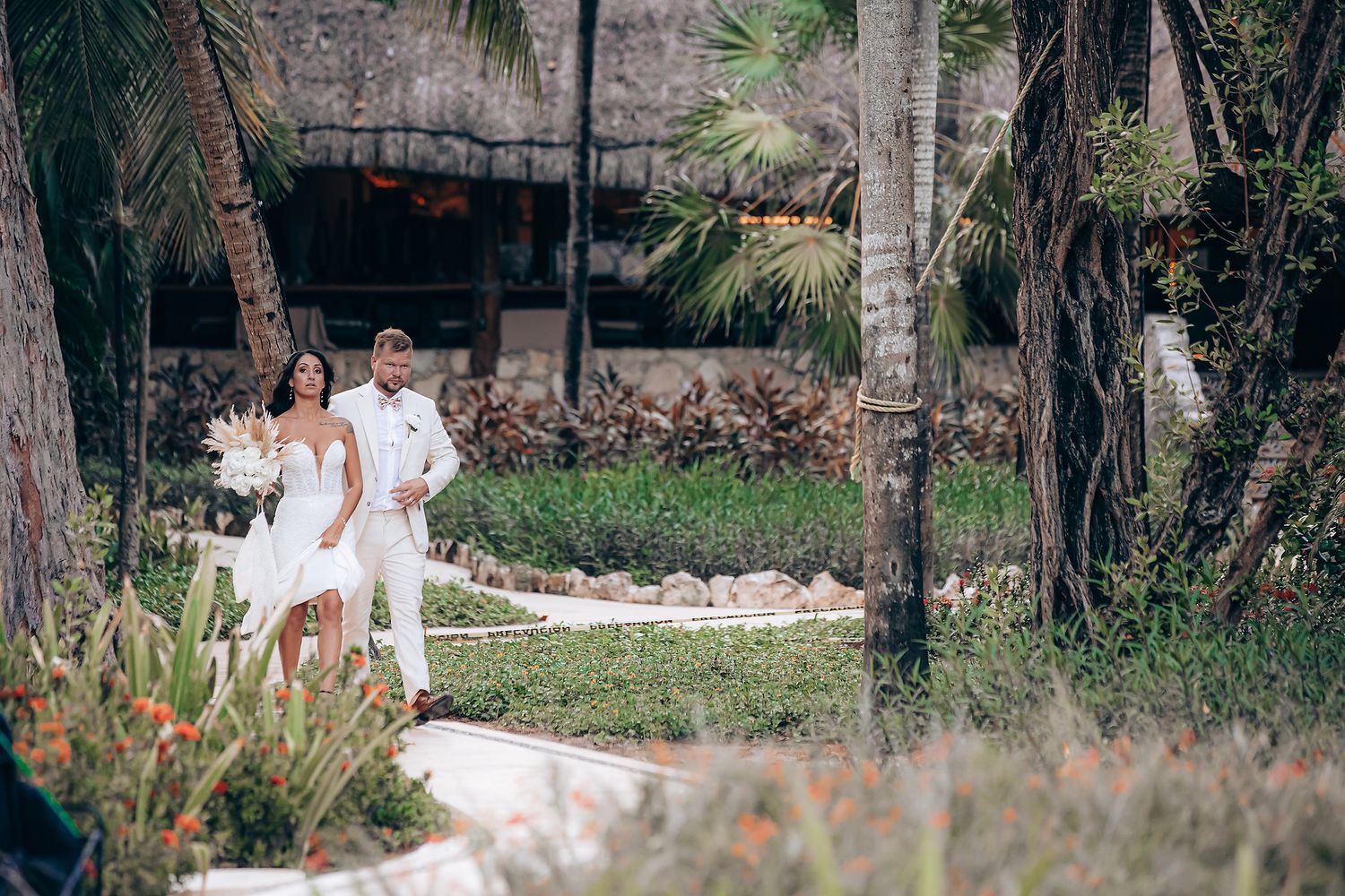 Wedding portraits captured in a natural garden setting with palm trees.