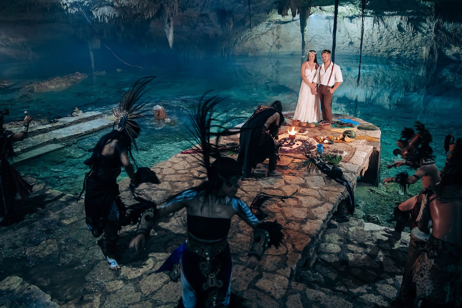 Atmospheric wedding photos captured in a dimly lit cave with natural rock formations creating a mystical backdrop.
