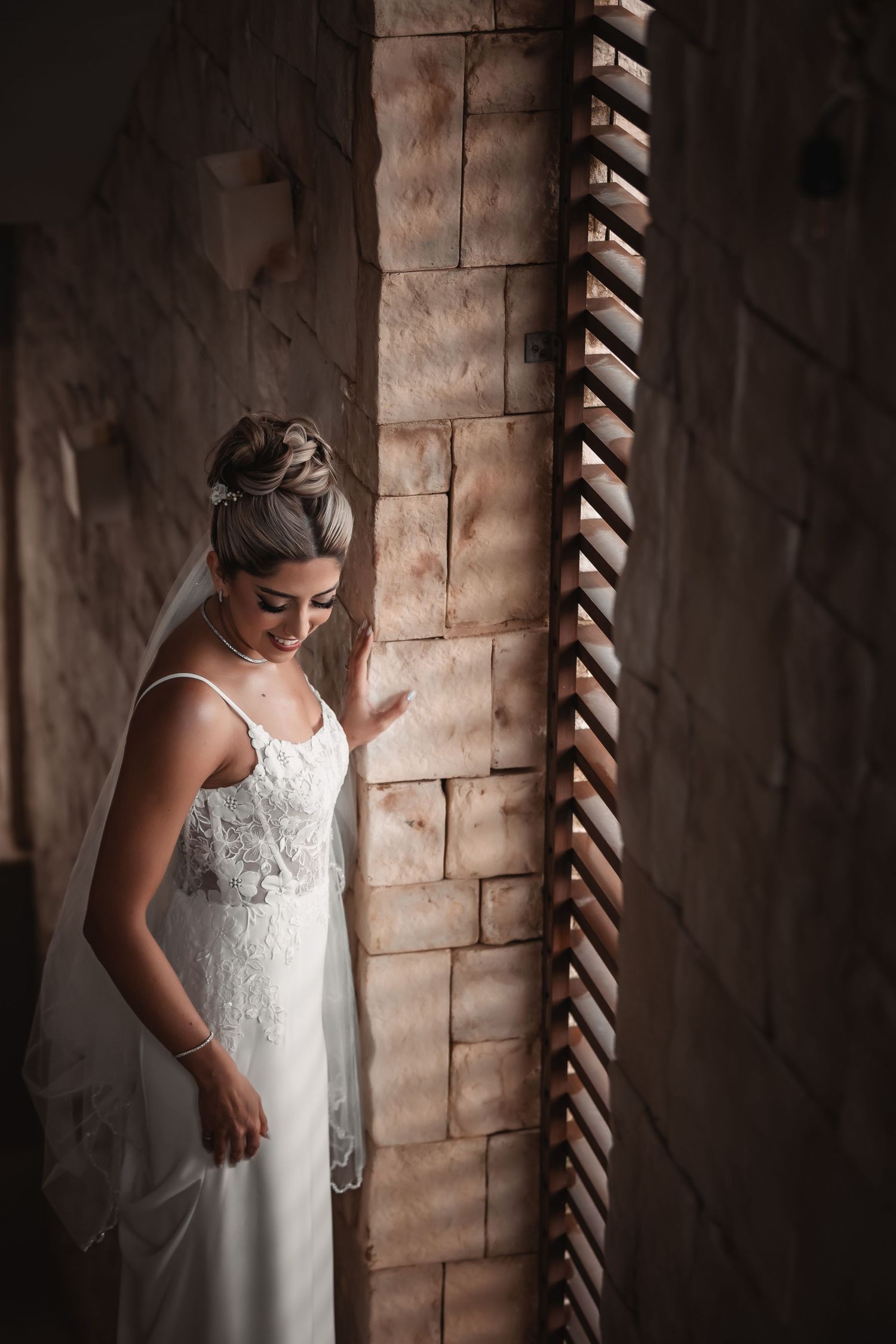 Elegant bridal portraits in a rustic stone archway showcasing a flowing white lace wedding gown.