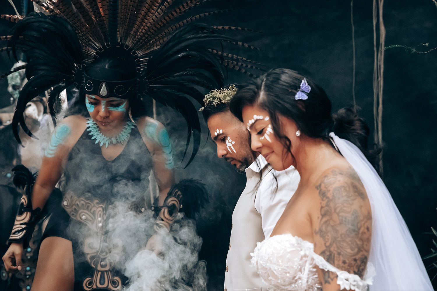 Romantic couple sharing an intimate moment with smoke effects in a moody outdoor setting.