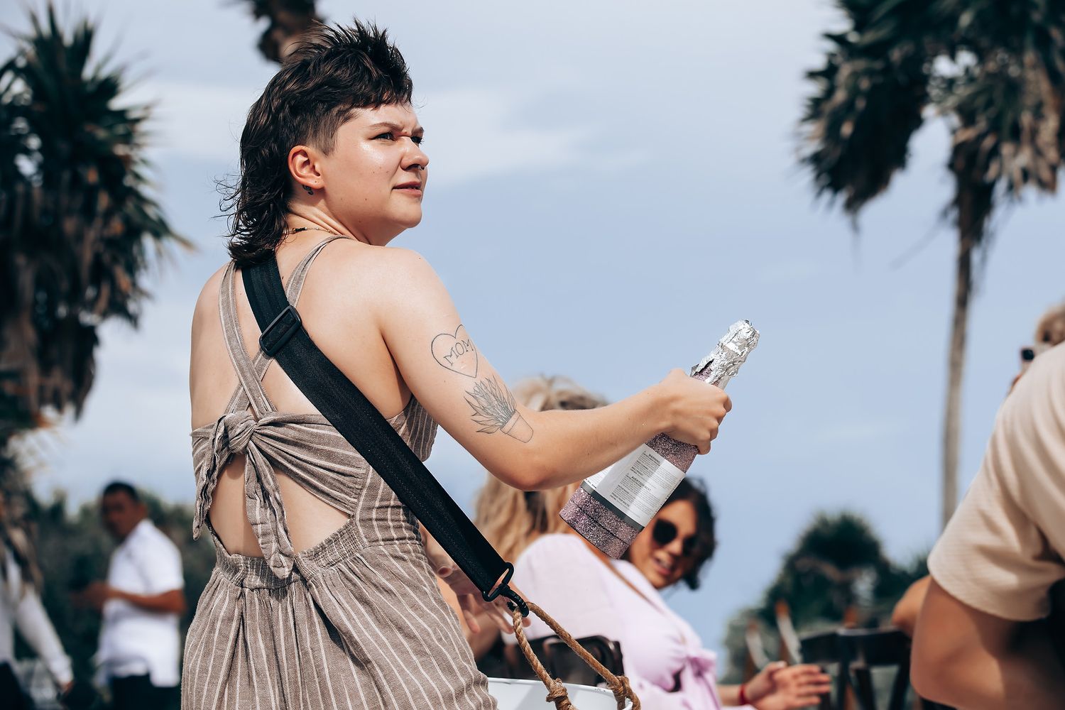 Wedding guests celebrate with drinks at a tropical outdoor reception.